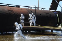 Members of the 902nd Civil Engineer Squadron fire department prepare to enter a burning aircraft at the Fire Training Area on Joint Base San Antonio-Randolph March 22. (U.S. Air Force photo by Rich McFadden) (released)