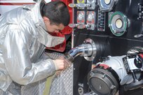 Airman 1st Class John Evans, 902nd Civil Engineer Squadron firefighter, connects a hose to a fire truck during live fire training at the fire training area on Joint Base San Antonio-Randolph, Texas March 22. (U.S. Air Force photo by Rich McFadden) (released)