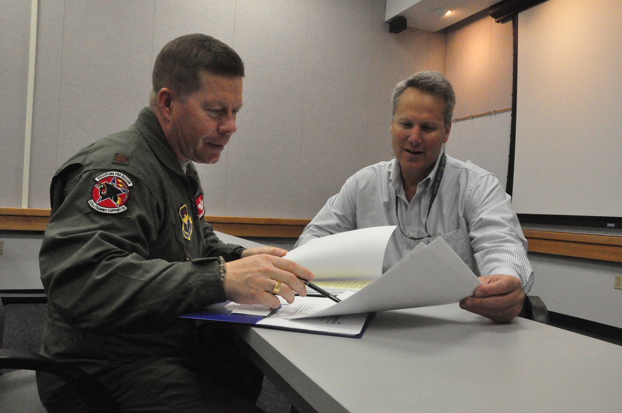 Maj. Rodney Lammert, 325th Training Support Squadron assitant director of operations, and Mr. Bradford Young, 325th TRSS F-22 modernization and training integration lead, discuss the F-22 modernization syllabus. (U.S. Air Force photo by Senior Airman Rachelle Elsea)