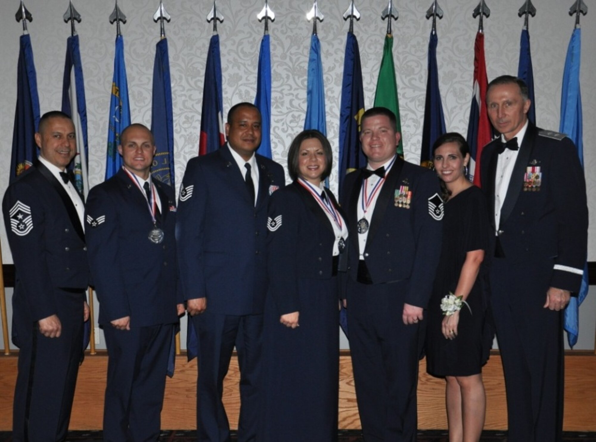 JOINT BASE McGUIRE-DIX-LAKESURST, N.J. -- Maj. Gen. Bill Bender, U.S. Air Force Expeditionary Center commander (far right) and Command Chief Master Sgt. Jeffrey Cui, Expeditionary Center command chief (far left), pose for a picture with the award nominees from EC units during the Air Mobility Command Outstanding Arimen of the Year banquet held at Scott AFB, Ill., March 21. The nominees, joined by their spouses, were Senior Airman Ryan Smith, 3rd Aerial Port Squadron, Pope Field, N.C., Tech. Sgt. Shannon Webster, 521st Air Mobility Operations Wing, and her husband Tech. Sgt. David Webster, 721st Aerial Port Squadron, Ramstein AB, Germany, Master Sgt. Joseph Neubauer, Mobility Operations School, and his wife Michelle Neubauer, Joint Base McGuire-Dix-Lakehurst, N.J.  (U.S. Air Force photo by 1st Lt. Sybil Taunton, U.S. Air Force Expeditionary Center Public Affairs)