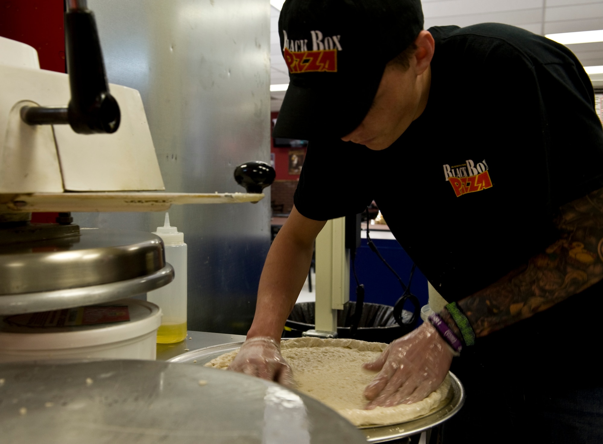 Devon Denomie, kitchen crew, forms pizza dough March 26, 2012, prior to the grand opening of Black Box Pizza at Dyess Air Force Base, Texas. Black Box Pizza is available by delivery to on-base residents as well as service members in Quail Hallow. For more information, call (325) 696-5555. (U.S. Air Force photo by Airman 1st Class Jonathan Stefanko/ Released)