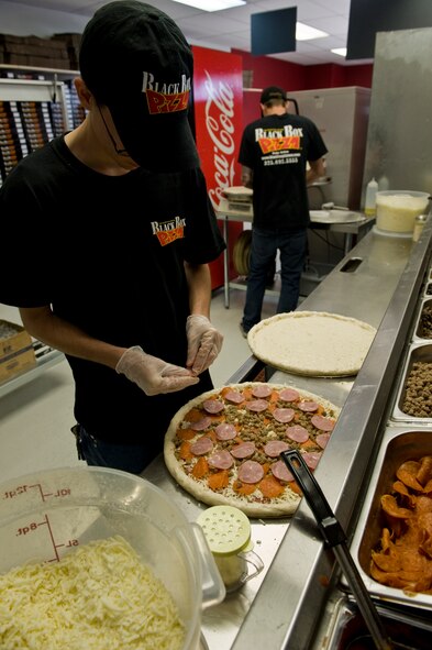 Joshua Blancato, kitchen crew, prepares a pizza March 26, 2012, during the grand opening of Black Box Pizza at Dyess Air Force Base, Texas. Black Box Pizza is available by delivery to on-base residents as well as servicemembers in Quail Hallow. For more information, call (325) 696-5555. (U.S. Air Force photo by Airman 1st Class Jonathan Stefanko/ Released)