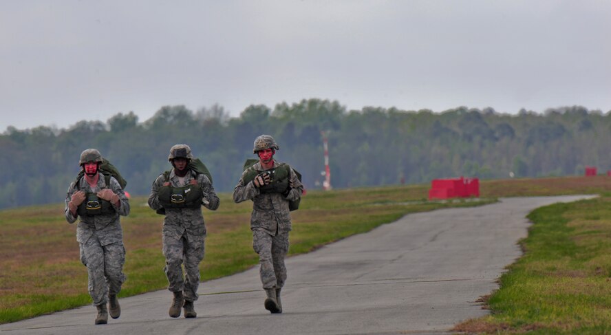 U.S. Air Force Staff Sgt. Ryan Pieper, Senior Airman Compton Harris and Airman 1st Class Fedor Potanin, 820th Base Defense Group, run to a rally point after their jump at Moody Air Force Base, Ga., March 21, 2012. This was Pieper and Potanin’s first jump with the squadron after completing the Basic Army Airborne Course. As part of a 15-year group tradition, Airmen conduct their first jump in the unit with their faces painted red.  (U.S. Air Force photo by Staff Sgt. Stephanie Mancha/Released)