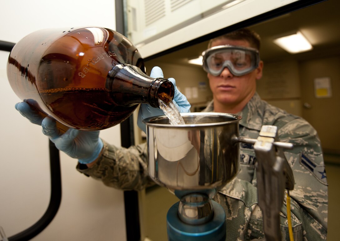 Airman 1st Class Collin Dunn, 28th Logistic Readiness Squadron fuels laboratory technician, pours aircraft fuel into a bottle method funnel during a test in the Fuels Lab at Ellsworth Air Force Base, S.D., March 22, 2012. Random samples are periodically tested before entering aircraft, to ensure that the safest, debris-free fuel is used. (U.S. Air Force photo by Airman 1st Class Kate Thornton/Released)
