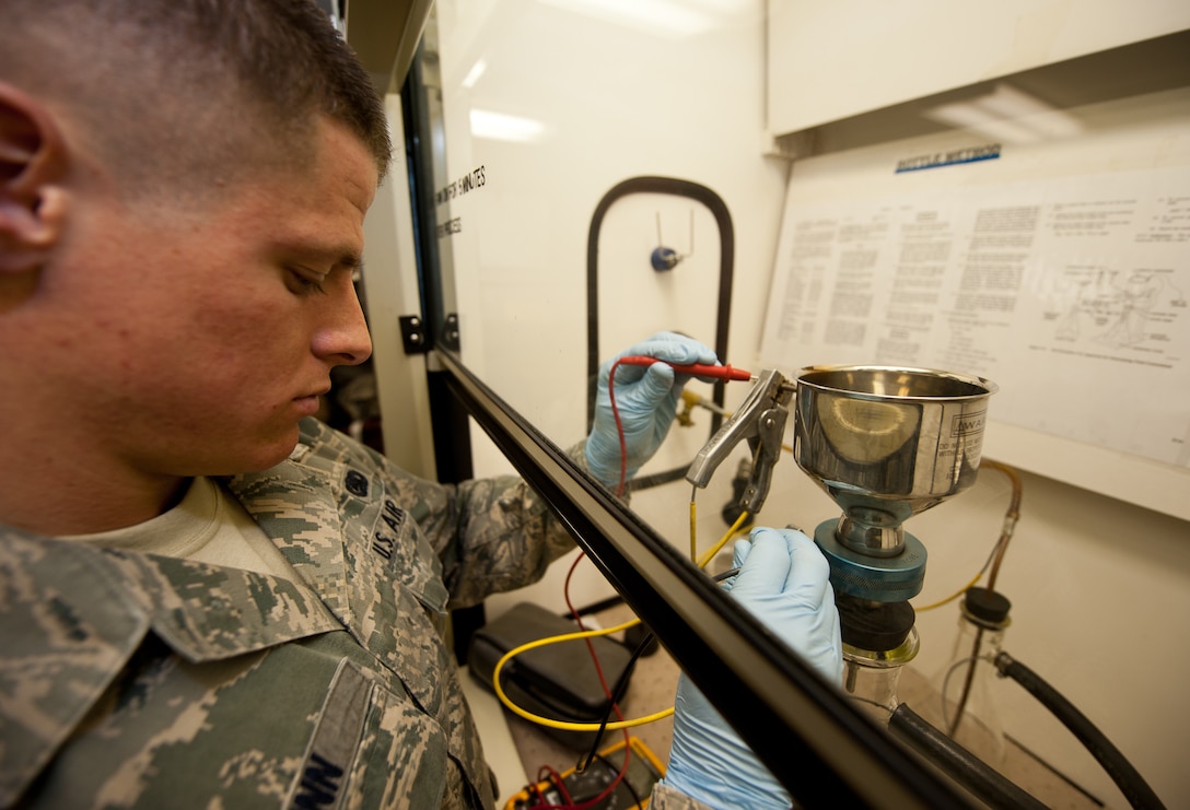Airman 1st Class Collin Dunn, 28th Logistic Readiness Squadron fuels laboratory technician, measures the electric resistance of a fuel sample during a bottle method test at the Fuels Lab on Ellsworth Air Force Base, S.D., March 22, 2012. Lab technicians ground fuel samples to prevent the risk of fire or explosion, during these measurements. (U.S. Air Force photo by Airman 1st Class Kate Thornton/Released)