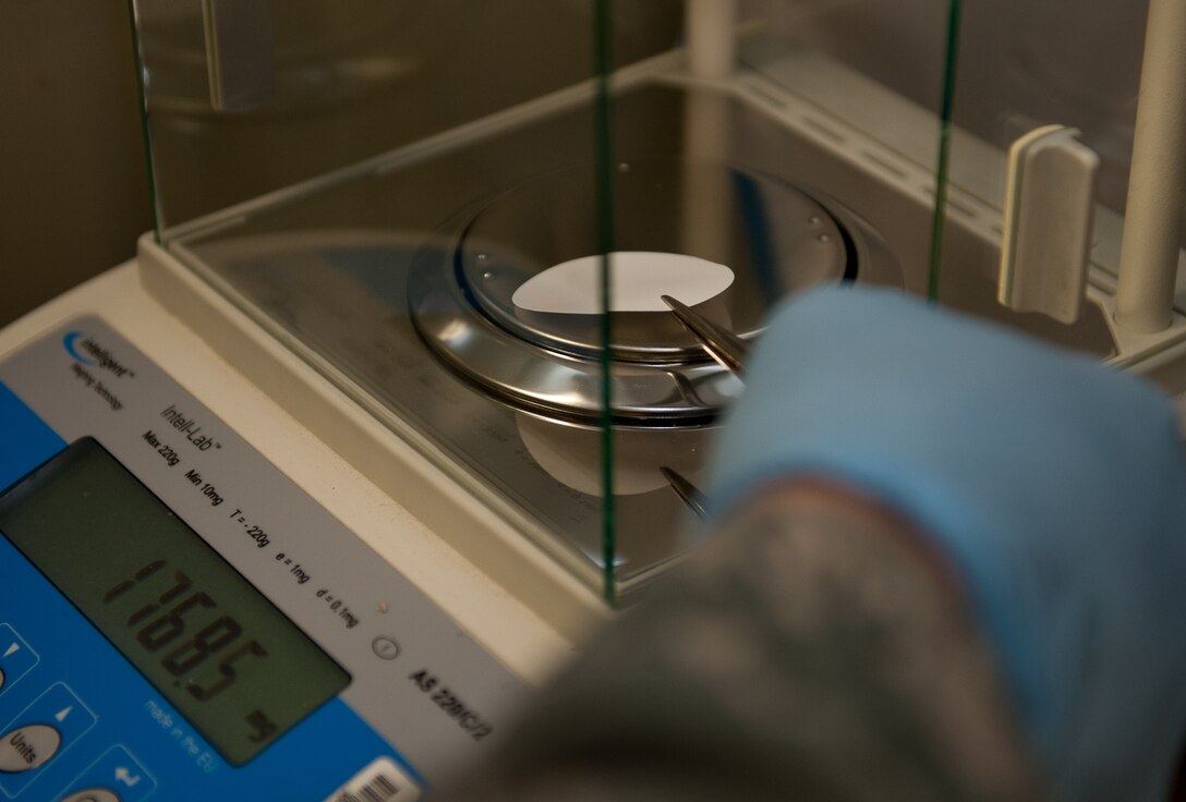 Airman 1st Class Collin Dunn, 28th Logistic Readiness Squadron fuels laboratory technician, weighs a bottle method filter pad during fuel testing at Ellsworth Air Force Base, S.D., March 22, 2012. The filter collects any impurities, such as sediment and particulates, that could lead to aircraft malfunctions and compromise safety. (U.S. Air Force photo by Airman 1st Class Kate Thornton/Released)