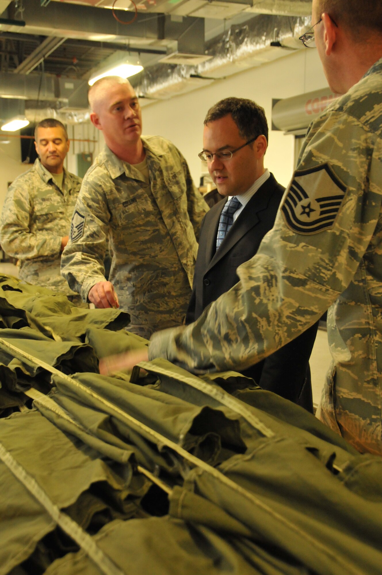 Master Sgt. Jeffrey Collins and Master Sgt. Stephen Johnson, both 153rd Logistics Readiness Squadron air transportation craftsmen, show the Honorable Daniel B. Ginsberg, Assistant Secretary of the Air Force for Manpower and Reserve Affairs, a parachute during a visit March 20, 2012. The secretary spoke with Airmen of the Wyoming Air National Guard and toured facilities. (Photo by 1st Lt. Rusty Ridley)