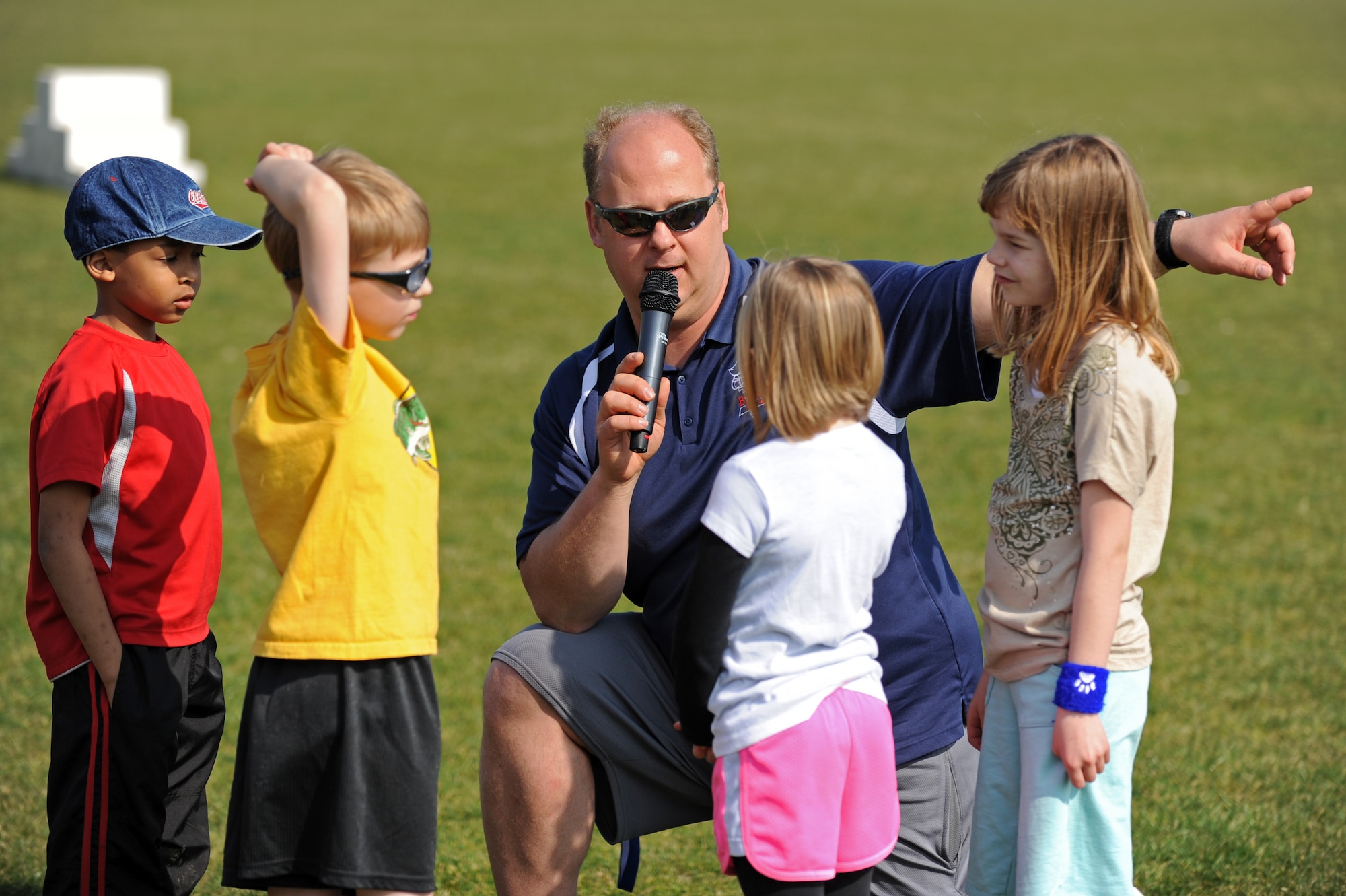 BITBURG ANNEX, Germany – Brian Bent, Bitburg High School track coach, talks with Spangdahlem and Bitburg Elementary School students during a track and field day at the Bitburg High School track here March 24. The BHS track team hosted the event to introduce the first- through sixth-grade students to the sport’s events. The team taught students about track and field to promote interest in staying active and healthy. (U.S. Air Force photo by Airman 1st Class Matthew B. Fredericks/Released)