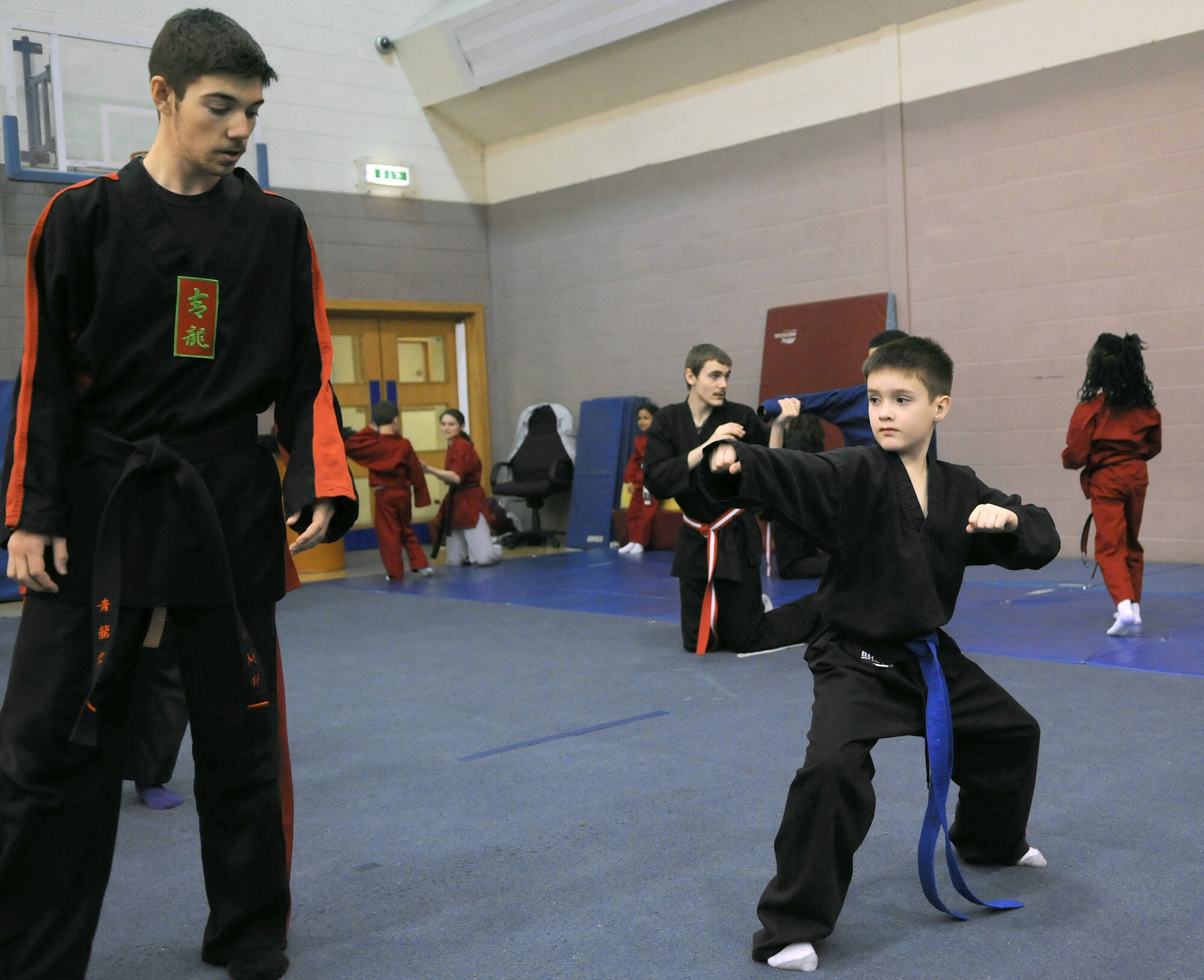RAF MILDENHALL, England -- Daniel McCollum  checks the form of Duncan Norwood’s punching ready stance during the RAF Mildenhall Youth Center’s Karate Camp March 15, 2012. As an advanced student in the martial arts class, McCollum assists the instructor with small group exercises and gives advice to other students. (U.S. Air Force photo/Staff Sgt. Thomas Trower)