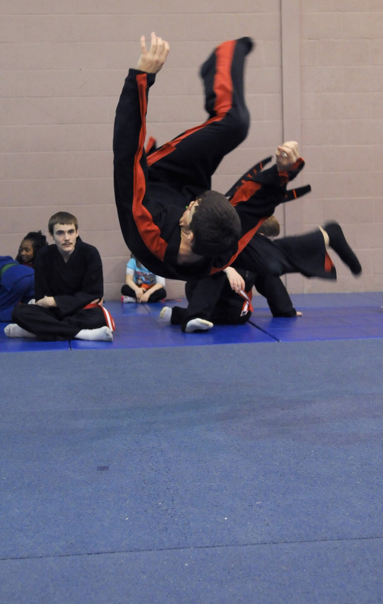 RAF MILDENHALL, England -- Daniel McCollum demonstrates how to flip and safely land on his back during a martial arts demonstration for students of the RAF Mildenhall Youth Center’s Karate Camp March 15, 2012. By showing junior students how to fall from greater heights without injury, McCollum can help them build confidence for use during floor exercises. (U.S. Air Force photo/Staff Sgt. Thomas Trower)