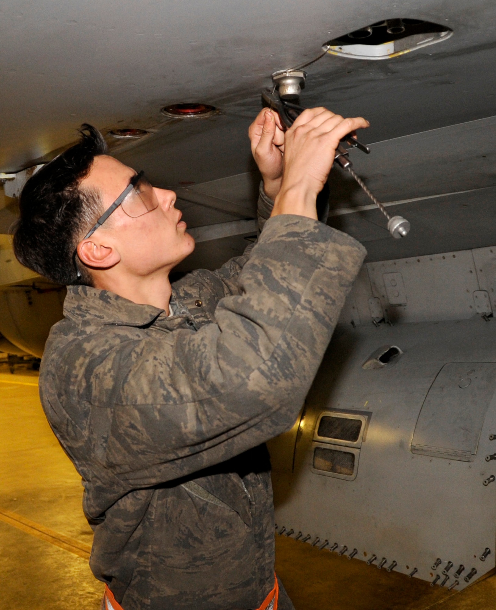 U.S. Air Force Senior Airman Howard Zumbrunnen, 13th Aircraft Maintenance Unit tactical maintainer, attaches safety wire to a nut on the bottom of a wing on a F-16 Fighting Falcon at Misawa Air Base, Japan, March 19, 2012. More than 70 Airmen from the 13th and 14th Fighter Squadrons and 35th Maintenance Group were flown to Paya Lebar Air Base, Singapore in support of Commando Sling, exercise that was created to help build relations with the people of Singapore and train U.S. Air Force pilots in a foreign environment. (U.S. Air Force photo by Airman 1st Class Kaleb Snay/Released)