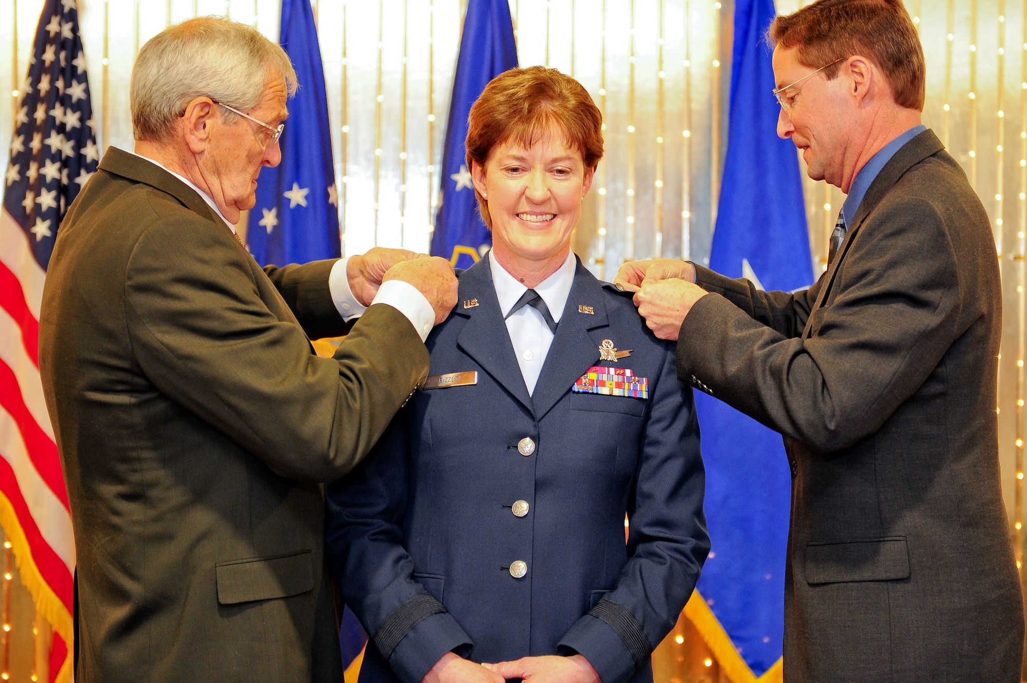 Brig. Gen. Karen A. Rizzuti, center, has her rank pinned on by her father, left, Lt. Col. (Ret) Al Priebel and her husband Tim Rizzuti during her promotion ceremony at Peterson Air Force Base, Colo. on Mar. 19. Rizzuti, the former 310th Space Wing commander is the Vice Commander of 10th Air Force, headquartered at Naval Air Station Fort Worth Joint Reserve Base, Texas. Rizzuti's family, friends and former co-workers were also in attendance at the promotion ceremony. (U.S. Air Force photo/Tech. Sgt. Nicholas B. Ontiveros).
