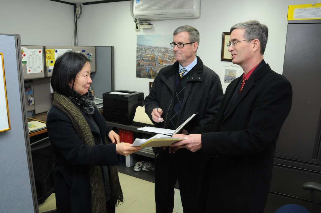 (Left to right) Kim Myong-son, FED Utilities and Services Branch, Walt Thompson, LRQA, and Kevin Shanahan, discuss some of the quality management processes of the Utilities and Services Branch Feb. 7.