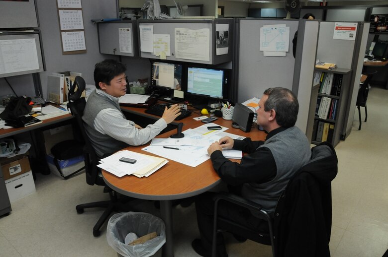 Sang Lee (left), FED Construction Division Quality Assurance Branch, discusses some of his processes with Jeff Sherman of LRQA Feb. 7.