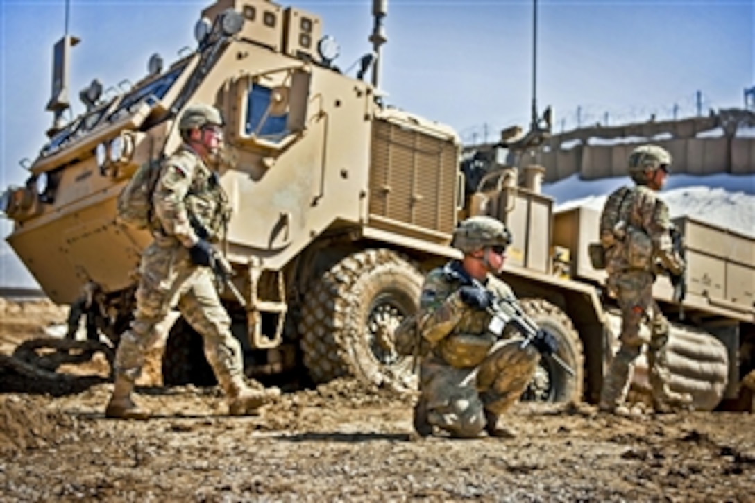 U.S. Army Spc. Tylor Calhoun (2nd from right) provides security while fellow soldiers work to recover their heavy expanded mobility tactical truck wrecker from thick mud during a clearing operation near Combat Outpost Deh Yak in Afghanistan's Ghazni province on March 6, 2012.  Calhoun is assigned to Company C, 1st Battalion, 2nd Infantry Regiment. U.S. and Afghan troops plan to disrupt insurgent movements into and through the area ahead of the spring fighting season.  