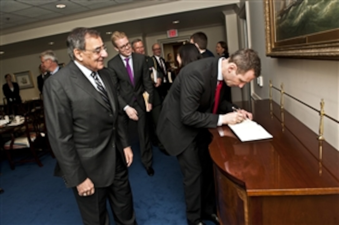U.S. Defense Secretary Leon E. Panetta looks on as Danish Defense Minister Nick Haekkerup signs the guest book at the Pentagon, March 26, 2012.