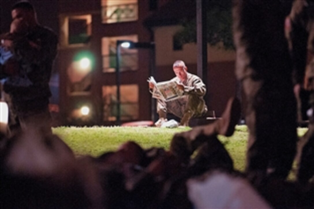 Army Capt. Rudy Stevens reads the latest issue of the Army Times as he waits for his unit to board buses for the airport to deploy to Afghanistan from Fort Bragg, N.C., March 21, 2012. Stevens is a chaplain assigned to the 2nd Battalion, 504th Parachute Infantry Regiment.