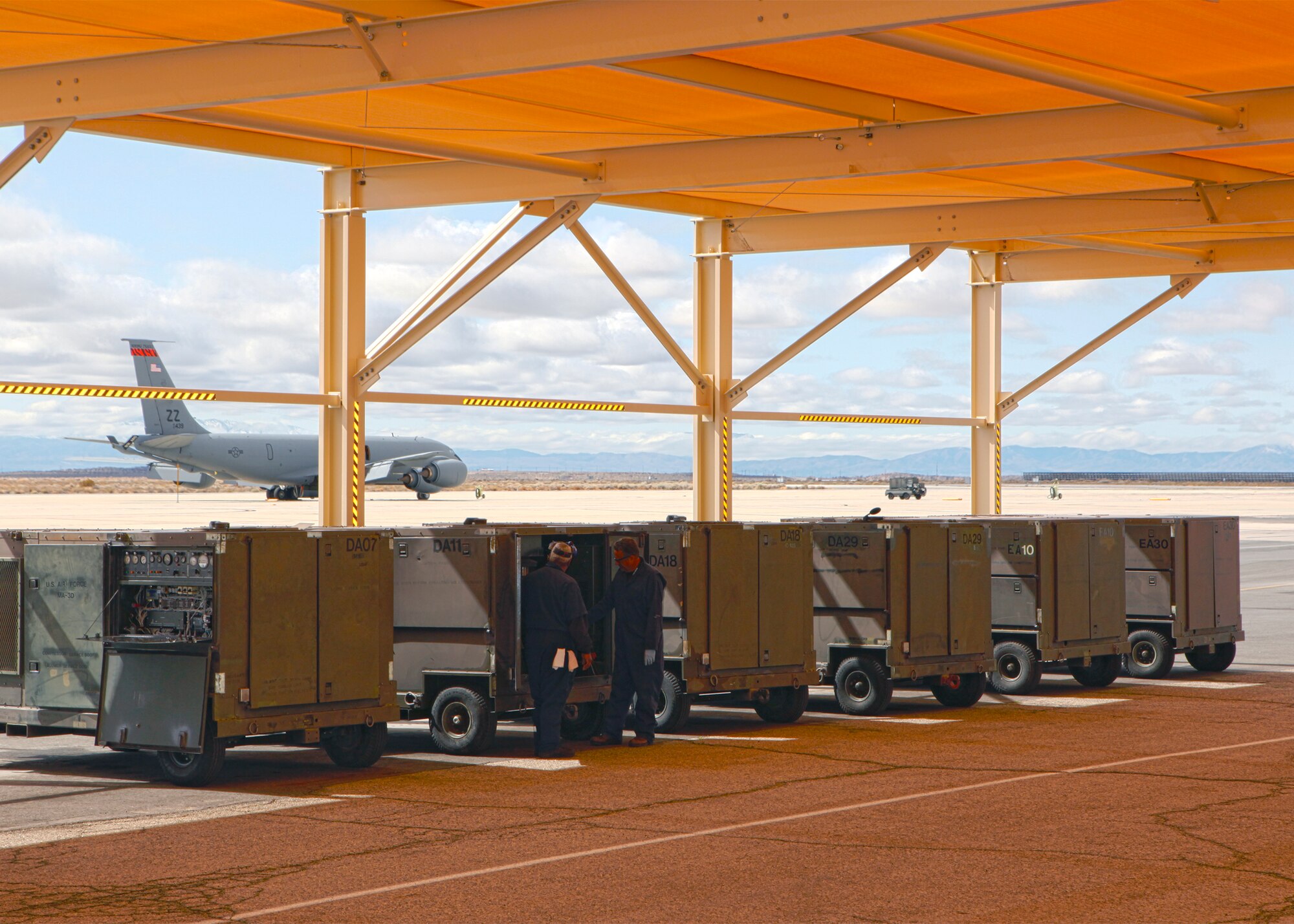 Two specialists from the 412th Maintenance Squadron Aerospace Ground Equipment flight inspect an MA-3D air conditioner under the newly-constructed sun shelter built for the AGE flight at Edwards March 26, 2012. The sun shelters are the latest addition of new aerospace ground equipment to the Edwards flightline. (U.S. Air Force photo by Jet Fabara)