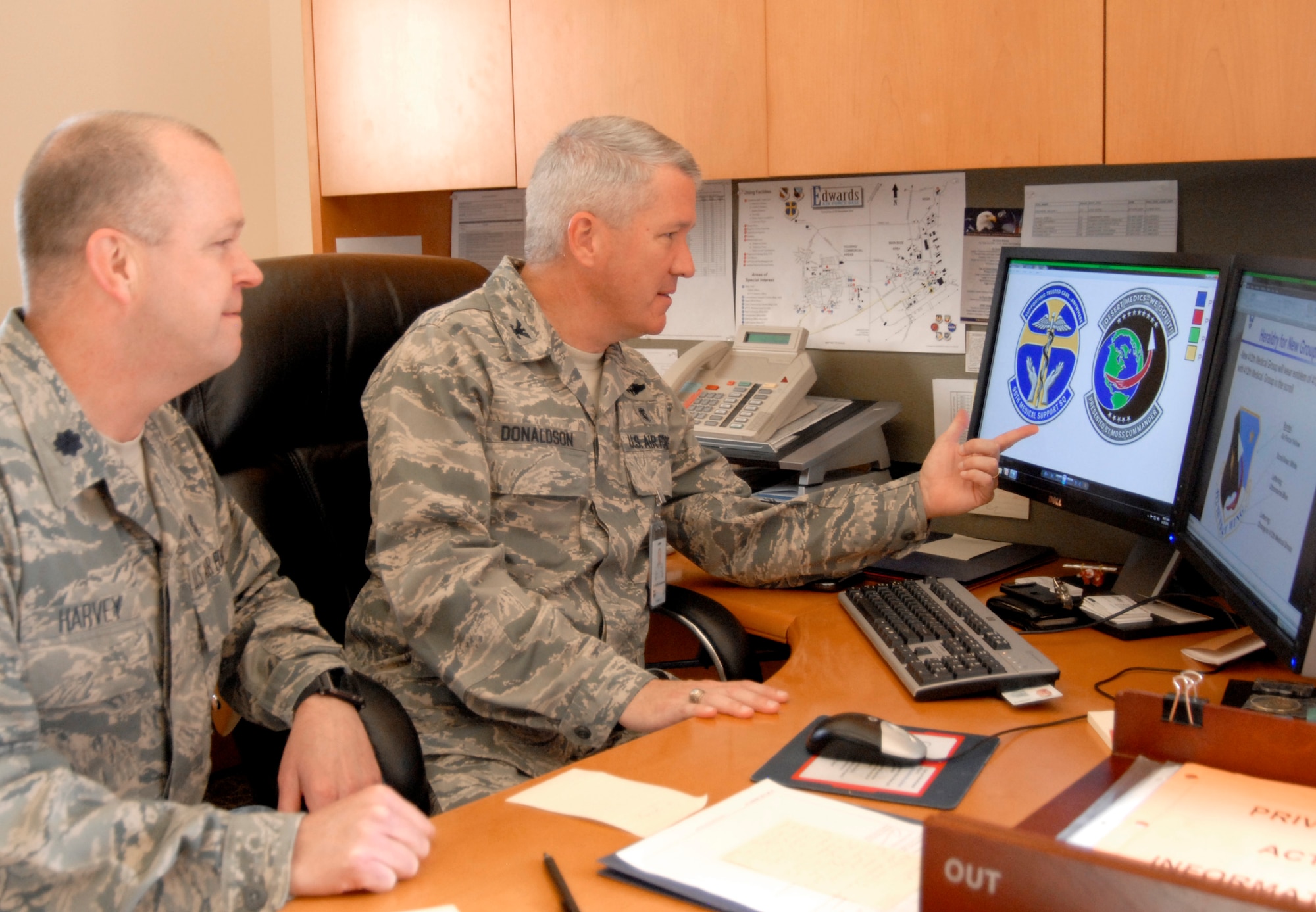 Col. Keith Donaldson, 95th Medical Group commander, looks over the beginning design of new heraldry for the 95th Medical Support Squadron with Lt. Col. Jerry Harvey, 95th MDSS commander. Squadrons in the 95th MDG began the design process for new heraldry in preparation for upcoming base structural changes. Dr. Stephanie Smith, Air Force Flight Test Center historian, has been instrumental in working with the squadrons and will continue to assist them throughout the heraldic process. (Air Force photo by Laura Mowry)