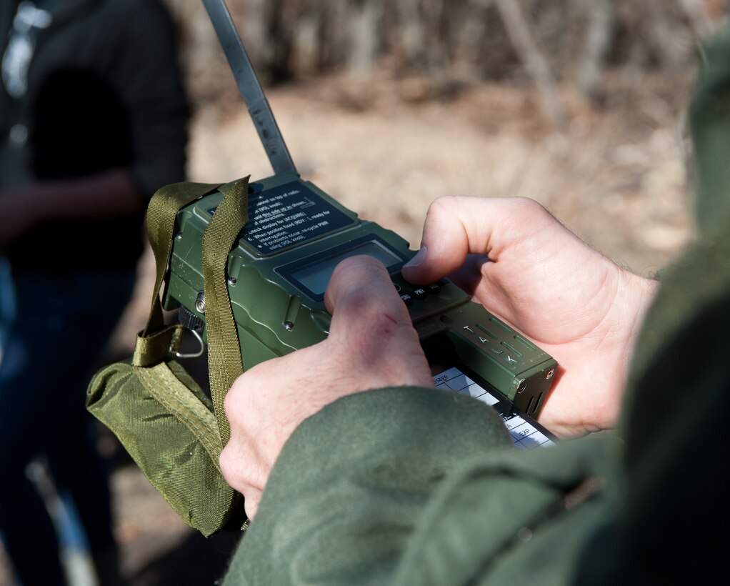 Maj. Keven McGlone, 37th Bomb Squadron assistant director of operations, enters coordinates on a AN-PRC 112 G radio before being sent out during an exercise at Sturgis Training Compound, Sturgis, S.D., March 22, 2012. These radios provided aircrews with coordinates used to navigate to set locations en route to their rescue. (U.S. Air Force photo by Airman 1st Class Alystria Maurer/Released)