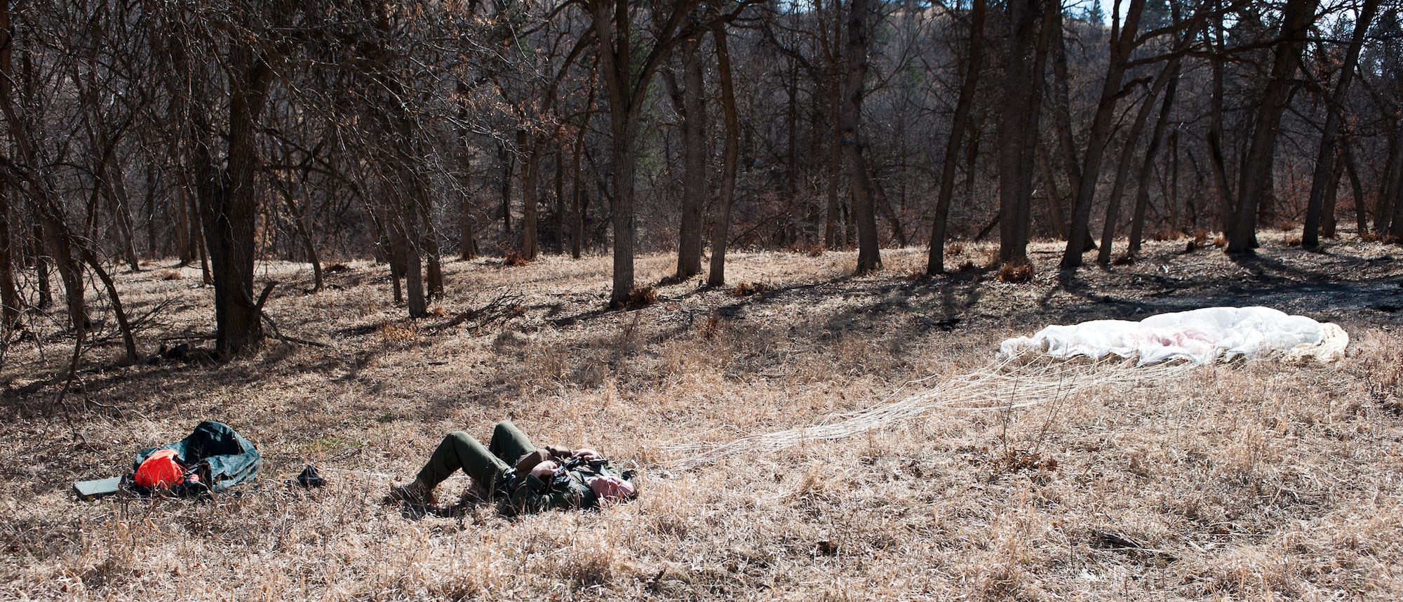 Senior Airman Brandon Dunphy, 28th Operations Support Squadron Survival Evasion Rescue Escape specialist, demonstrates steps taken following  a crash landing behind enemy lines, at the Sturgis Training Compound, Sturgis, S.D., March 22, 2012. After observing this demonstration, aircrews were expected to carry out these steps on their own. (U.S. Air Force photo by Airman 1st Class Alystria Maurer/Released)