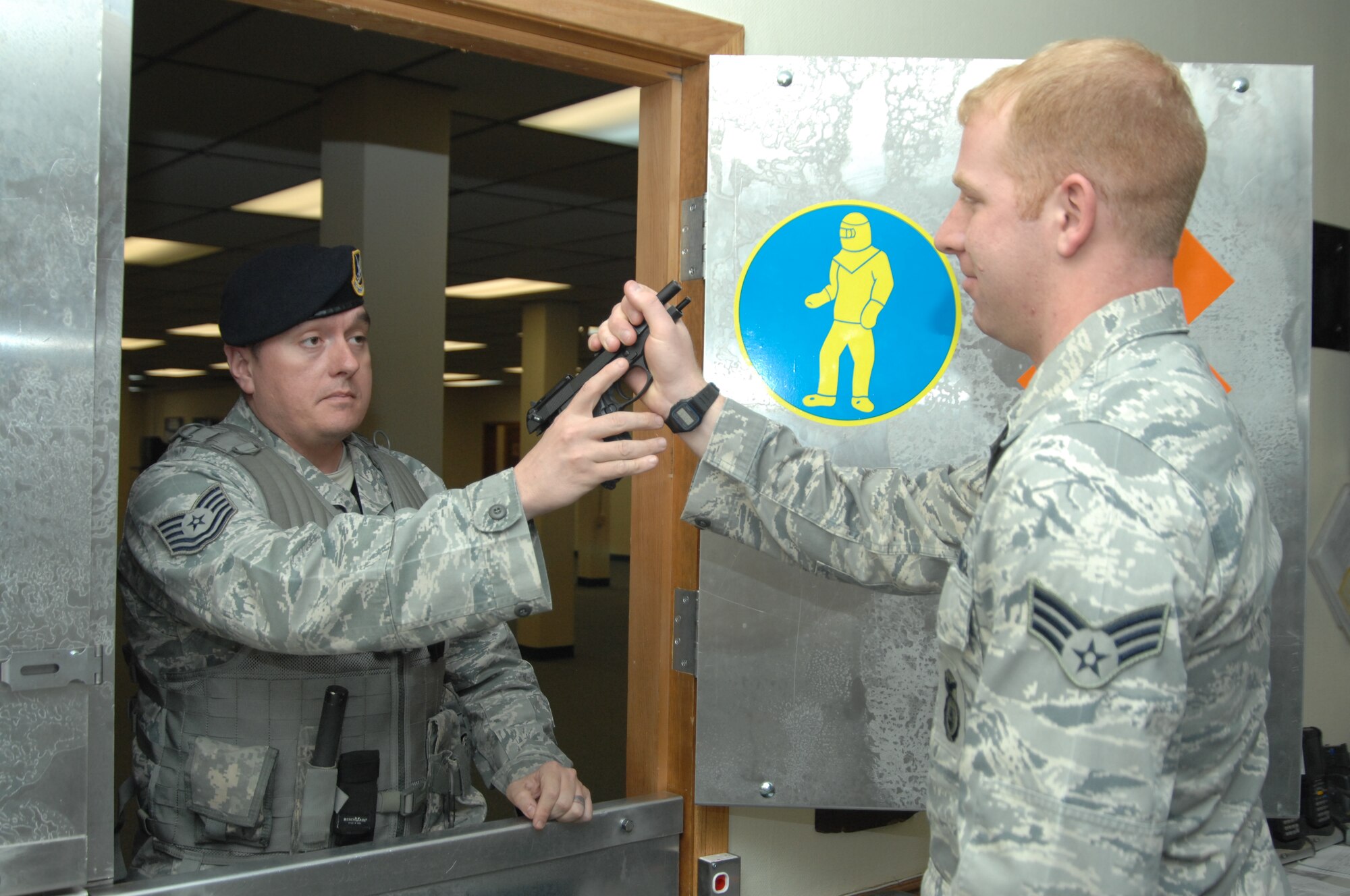 U.S. Air Force Tech. Sgt. Robert Stockdill, 366th Security Forces Squadron flight chief, is issued an M-9 Beretta from Senior Airman Andrew Keating, 366th SFS armorer, March 27, 2012, at Mountain Home Air Force Base, Idaho. The base armory is responsible for repairing and redistributing weapons to SFS personnel every day. (U.S. Air Force photo/ Senior Airman Benjamin Sutton) 