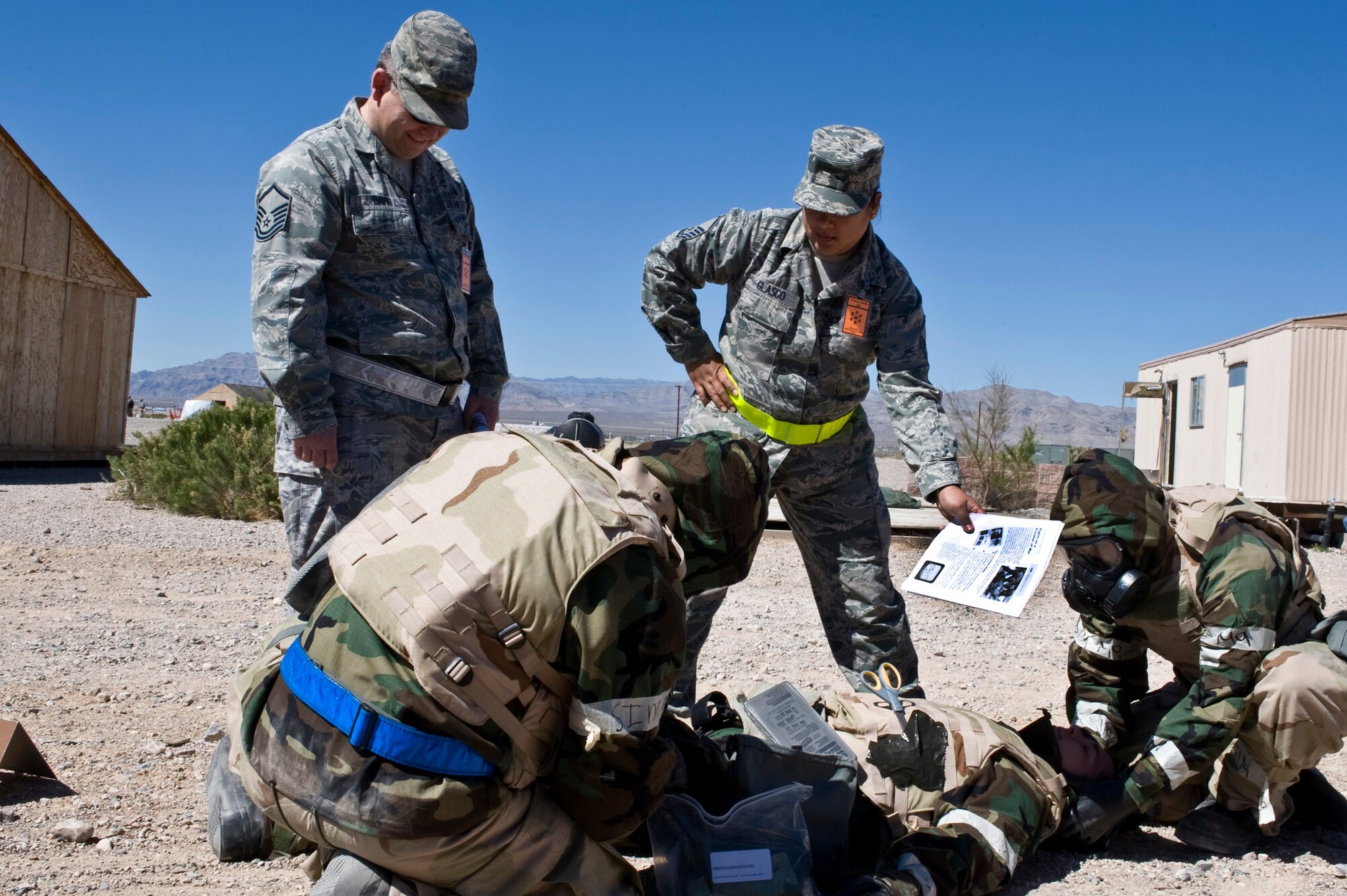 U.S. Air Force Master Sgt. Lloyd Davis, 99th Medical Group  readiness flight chief and Master Sgt. Cassandra Glasco, 99th Medical Operations Squadron emergency room flight chief, evaluates Airmen on self aid and buddy care during an Operational Readiness Exercise, March 21, 2012, at Nellis Air Force Base, Nev. SABC training prepares Airmen to perform as first-line medical responders in a wartime or peacetime environment. (U.S. Air Force photo by Airman 1st Class Matthew Lancaster)