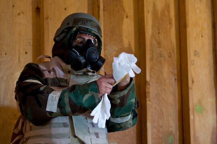 U.S. Air Force Staff Sgt. William Bittner, 99th Civil Engineer Squadron heavy equipment operator, puts on Mission Oriented Protective Posture gear during an Operational Readiness Exercise, March 21, 2012, at Nellis Air Force Base, Nev. The Ability to Survive and Operate training portion of the ORE tested Airmen on base defense tactics. (U.S. Air Force photo by Airman 1st Class Matthew Lancaster)