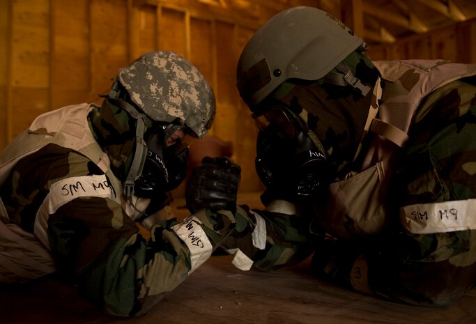 U.S. Air Force Tech. Sgt. Shawn Konen, 99th Civil Engineer Squadron structures craftsman, and Staff. Sgt. Louis Martinez, 99th Civil Engineer Squadron heavy equipment craftsman, pass the time by arm wrestling during an Operational Readiness Exercise, March 21, 2012, at Nellis Air Force Base, Nev. 43 Airmen participated in the Ability to Survive and Operate training portion of the ORE.(U.S. Air Force photo by Airman 1st Class Daniel Hughes)
