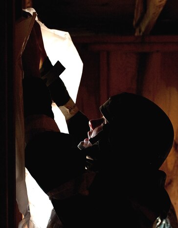 U.S. Air Force Senior Airman  Brennen Bychinski, 99th Civil Engineer Squadron heavy equipment operator, blocks off an entryway prior to a simulated chemical attack during an Operational Readiness Exercise March 21, 2012 at Nellis Air Force Base, Nev. The ORE tested Airmen's ability to survive and operate in a chemical environment while continuing with daily operations. (U.S. Air Force photo by Staff Sgt. Christopher Hubenthal)