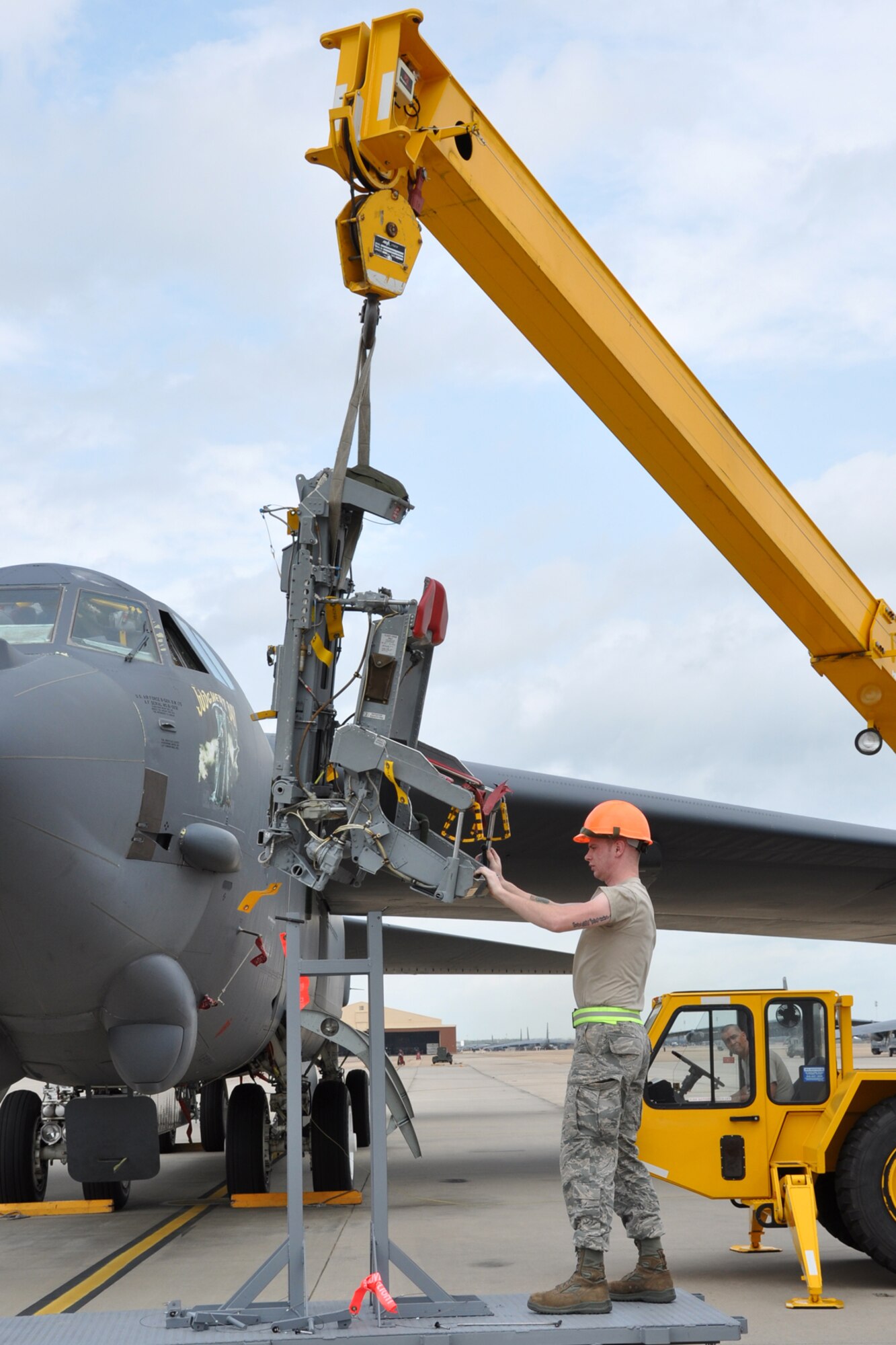 Crane operator, Tech. Sgt. Phillip Ozment, looks on as Senior Airman Shawn Layou guides an ejection seat from a stand at Barksdale Air Force Base, La., March 19, 2012. Both Airmen are egress technicians assigned to the 2nd Maintenance Squadron, who are working hand-in-hand with 307th Bomb Wing maintenance personnel to re-install ejection seats in a B-52 Startofortress after other components of the jet were replaced. (U.S. Air force photo by Master Sgt. Jeff Walston/Released)