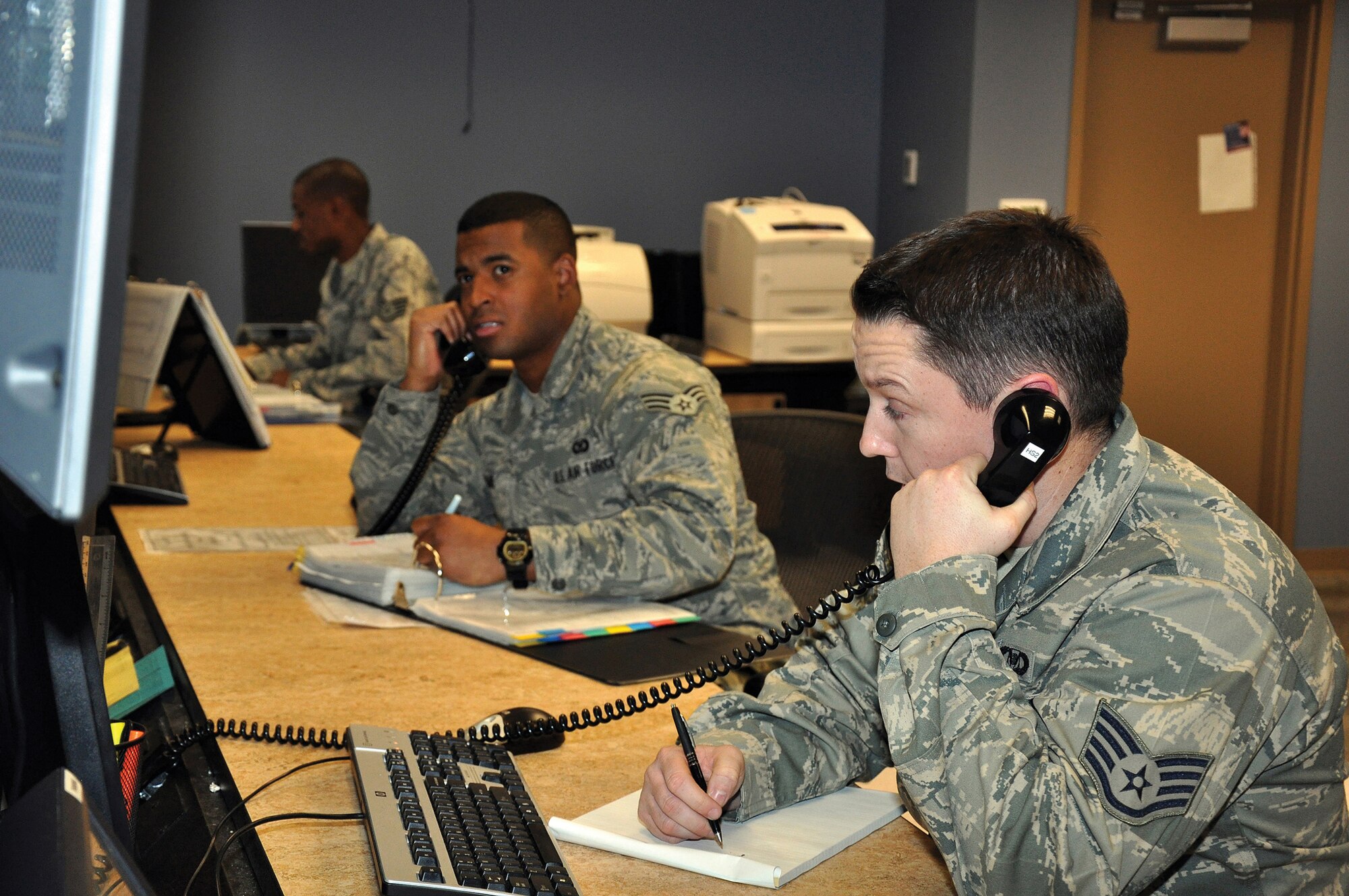 From left, Staff Sgt. Tracy Ford, Senior Airman Christopher Adams and Staff Sgt. Chad Green man the Maxwell Combined Command Post, a merging of active-duty and Reserve personnel that acts as the nerve center of the base.