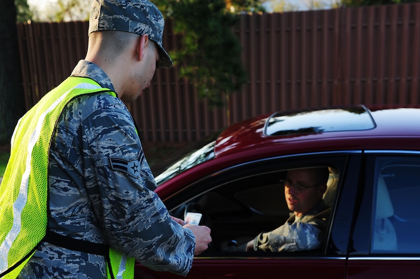 U.S. Air Force Airman 1st Class Israel Medina, 1st Operations Support Squadron, verifies the identity of an Airman driving onto Langley Air Force Base, Va., March 14, 2012.  Prior to manning the gates, 633rd Security Forces trainers ensure augmentees can recognize various types of identification cards, enforce base entry requirements, direct traffic flow, and prevent security breaches. (U.S. Air Force photo by Airman 1st Class Kayla Newman/Released)