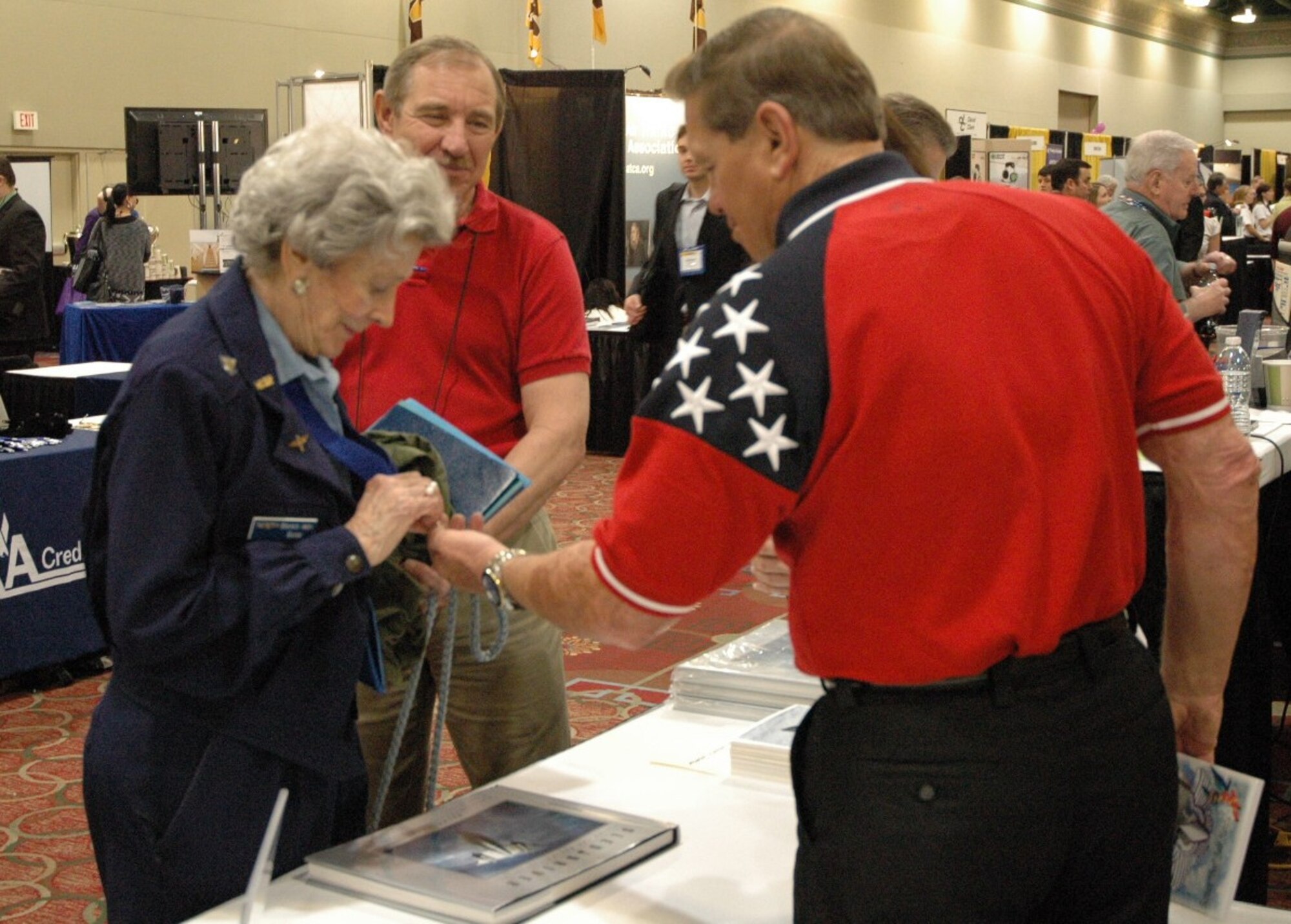 SR-71 Blackbird pilot and inspirational speaker Brian Shul admires Bernice "Bee" Falk Haydu's Congressional Gold Medal at the 2012 International Women in Aviation Conference in Dallas, Texas, March 8-10. Haydu, a WWII Women Airforce Service Pilot and 2012 inductee into the WIA International Pioneer Hall of Fame, presented Shul with a copy of her book, Letters Home 1944-45, during their chat. (U.S. Air Force photo/Dana Lineback)