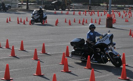 A police officer shows off his maneuvering skills March 23 during the Seventh Annual Palmetto Police Motorcycle Rodeo. The rodeo was one of the stops during the 2012 Joint Base Charleston Motorcycle Safety Event. The event provided motorcyclists with information about safe riding, motorcycle laws in South Carolina, military regulations and proper riding equipment.  (U.S. Air Force photo/Airman 1st Class Jared Trimarchi)