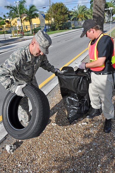 Senior Airman Mathew Cantone, 482 Fighter Wing Maintenance Squadron picks up a littered tire in a median on Thursday morning Mar. 22., while participating in the Adopt-a-Highway cleanup day.  SrA Cantone teamed up with young student from Homestead Job Corps picking up litter throughout the morning together as a team. (U. S. Air Force Photo/Staff Sgt. Lou Burton, 482nd Fighter Wing Public Affairs).     