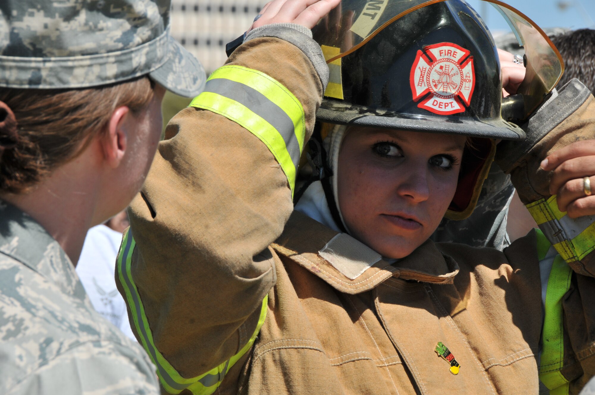 SAN ANGELO, Texas – Cadet Fourth Class, Katelyn Reed, Air Force Reserve Officers’ Training Corps Detachment 847 member, dons fire protective gear as Tech. Sgt. Lesie Whitney describes each piece of equipment during a Junior ROTC drill competition meet at Angelo State University March 24. (U.S. Air Force photo/ Staff Sgt. Tong Duong)
