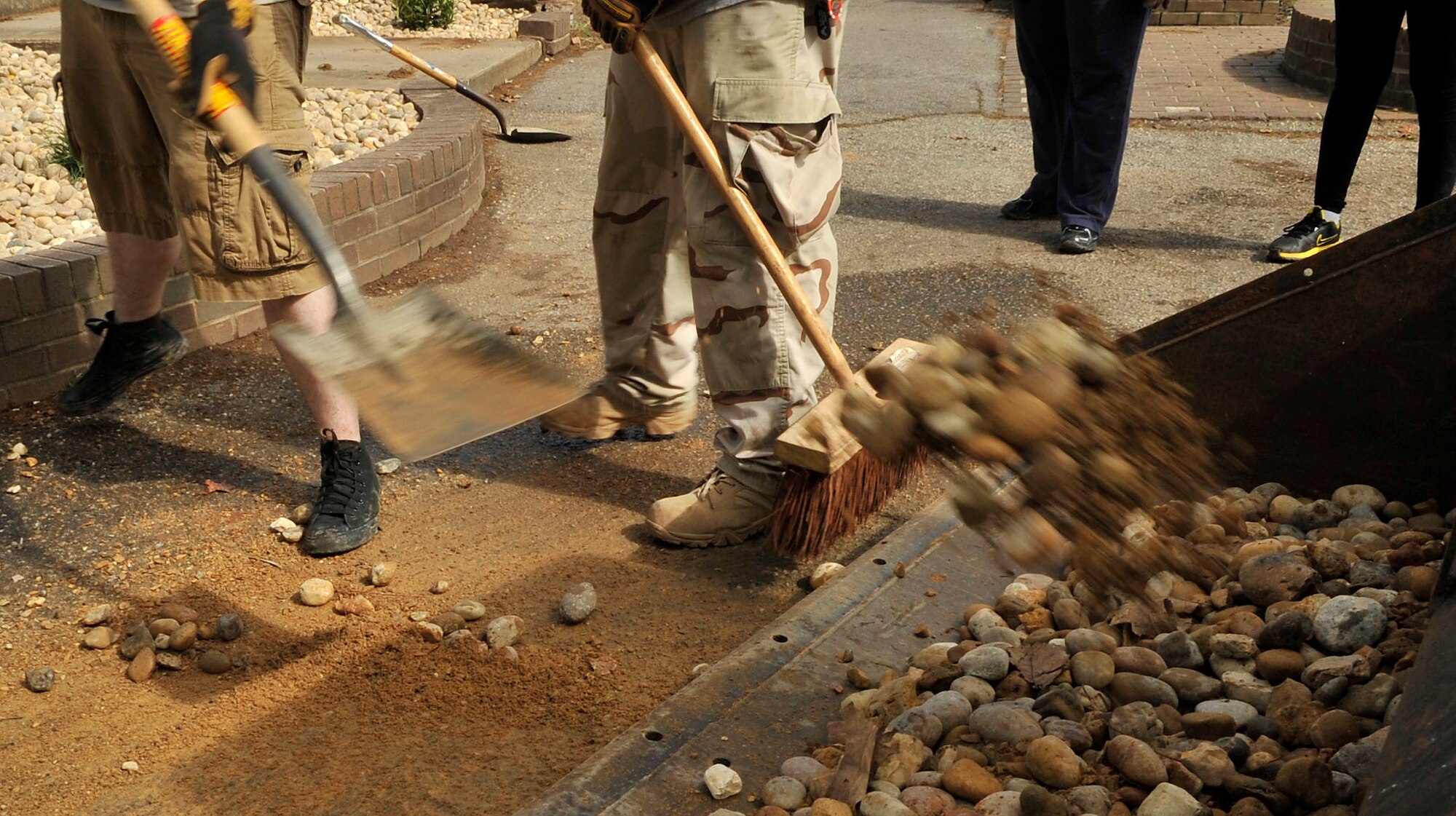 U.S. Air Force Airmen clean up extra rocks from the landscape restorations at Carolina Lakes Golf Course at Shaw Air Force Base, S.C., March 24, 2012. These Airmen helped to lay rocks, plant bushes and flowers, and also pick up natural debri.(U.S. Air Force photo by Airman Nicole Sikorski/Released)

