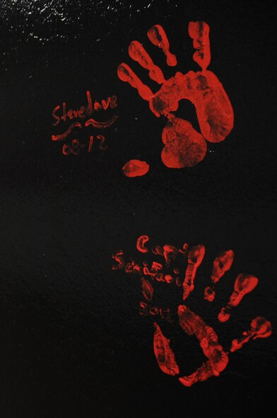 When Airmen leave the 96th Aircraft Maintenance Unit they dip a hand in red paint and place it on a pillar in the 96 AMU heritage room. Once the hand print is made, the departing member signs his or her name next to it. The hand prints represent those who had a hand in building the unit and making it what it is today. (U.S. Air Force photo/Airman 1st Class Micaiah Anthony)(RELEASED)