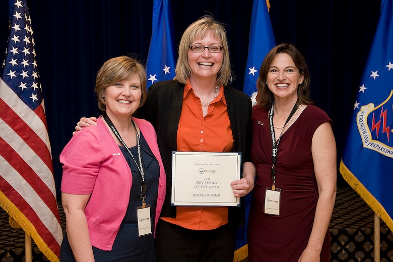 Miranda Sherman (center), receives the 2011 Key Spouse of the Year Award from Kayreen Crawford (left), and Meegan Flewelling (right), senior key spouse mentors, March 23 at The Club. The Key Spouse program consists of approximately 40 spouses selected and supervised by unit commanders to support families, especially when a member is deployed. (Photo by Craig Denton)