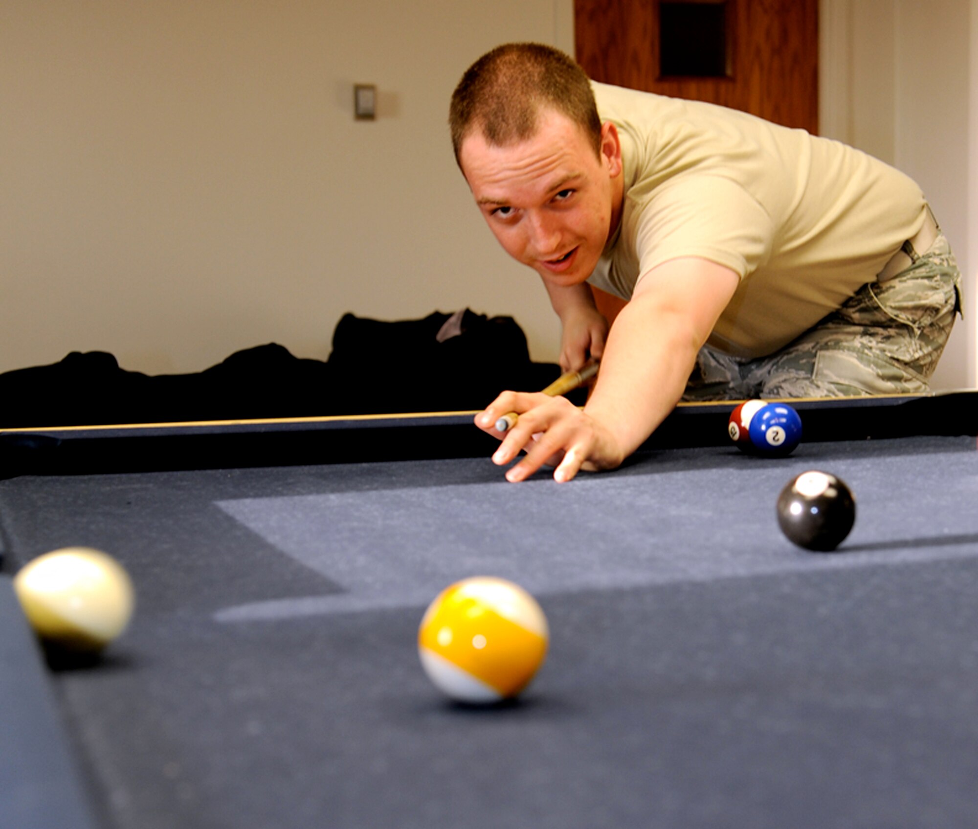 Airman 1st Class Zach Krotzer, with the 71st Communications Squadron, shoots pool at the Community Chapel Activity Center during Single Airmen night held at Vance Air Force Base, Okla., March 16.  More than 30 Airmen attended this month’s Single Airmen night, where they enjoyed soda, salad and pizza. (U.S. Air Force photo/ Airman 1st Class Frank John Casciotta)