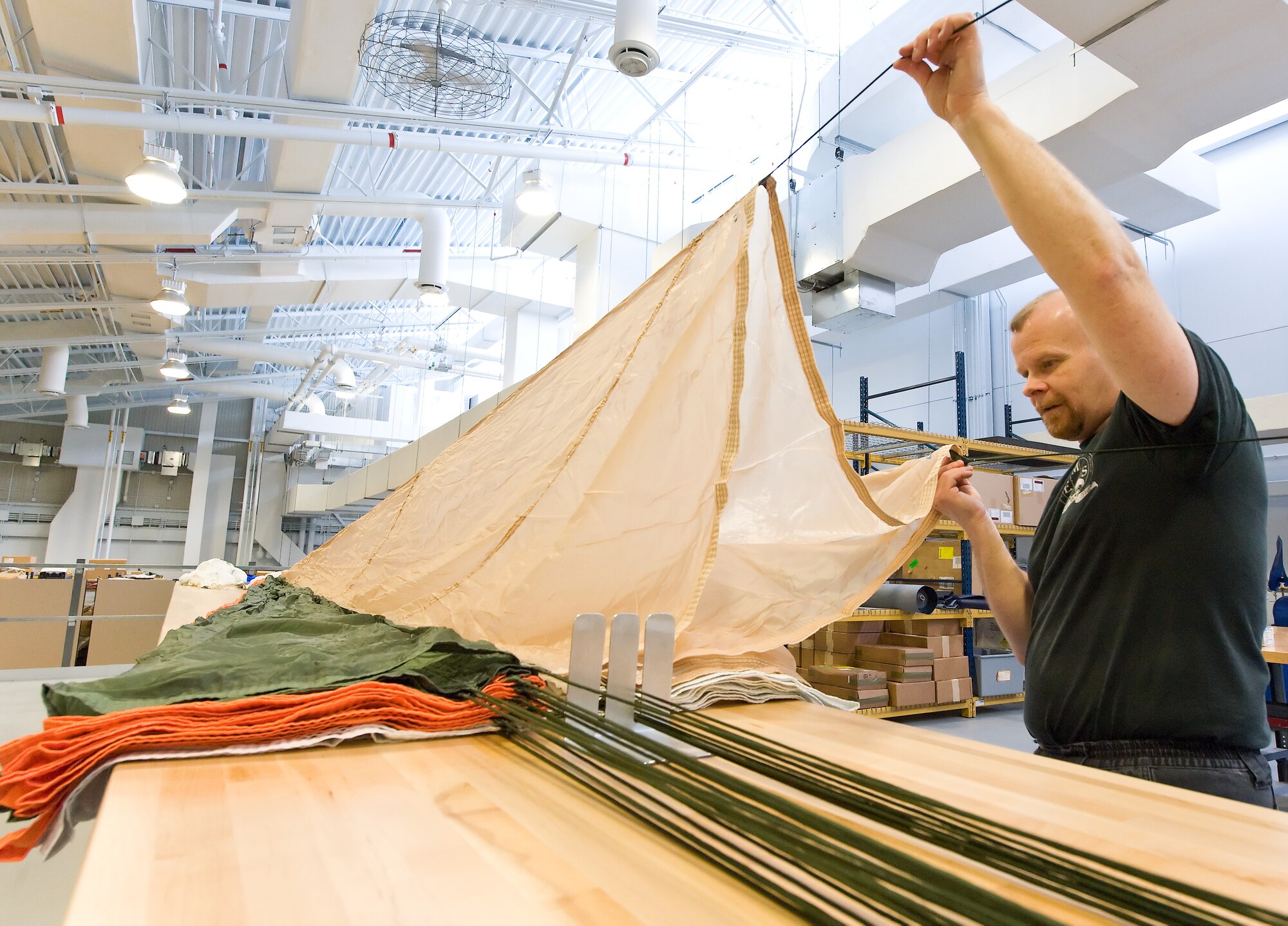 Dave Compton, an aircrew flight equipment technician with the 436th Operations Support Squadron Aircrew Flight Equipment section, airs out and inspects a BA-22 back-style emergency parachute March 19, 2012, at Dover Air Force Base, Del. Compton inspected the parachute for tears and twisted lines prior to repacking. (U.S. Air Force photo by Roland Balik)
