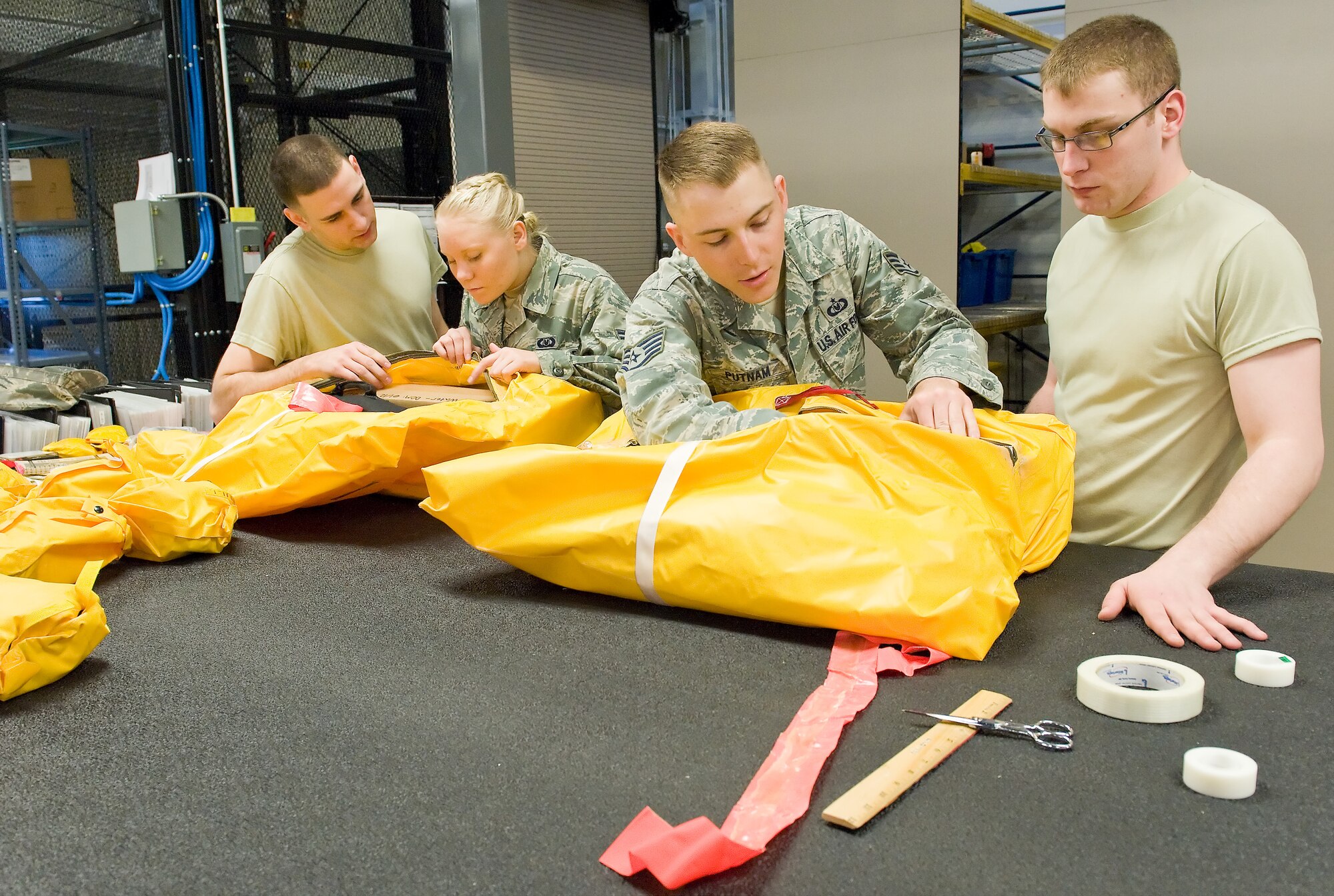 Members of the 436th Operations Support Squadron Aircrew Flight Equipment section pack a C-17 Globemaster III 46-man survival kit March 19, 2012, at Dover Air Force Base, Del. Each C-17 has three survival kits onboard that undergo inspection every four years. (U.S. Air Force photo by Roland Balik)
