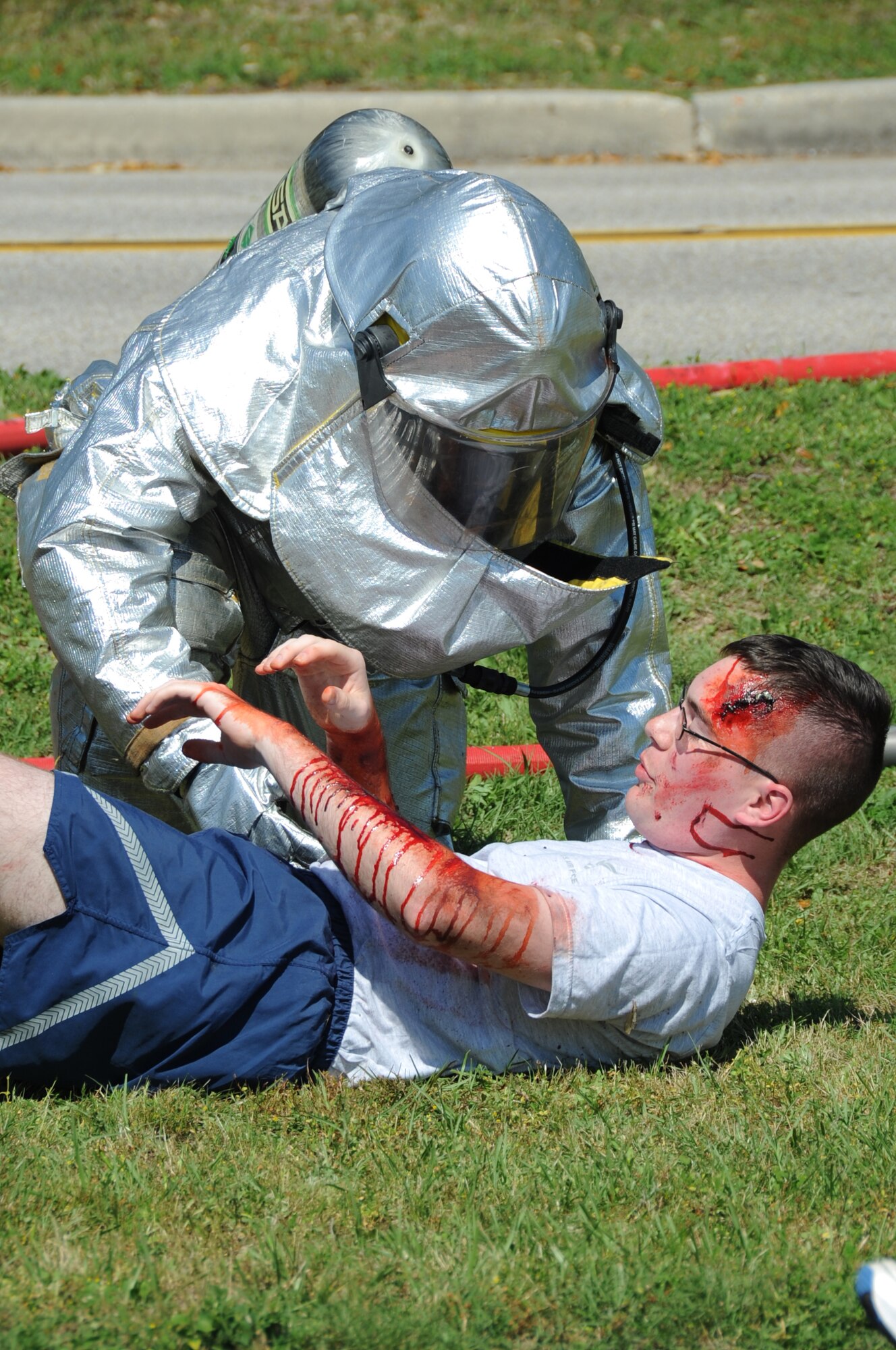 A Keesler firefighter offers assistance to “injured” Airman first Class Joseph Murray, 338th Training Squadron, on the scene of a major accident response exercise March 26, 2012, on I-81 across from the Marina at Keesler Air Force Base, Miss.  Prior to the exercise, those who volunteered to play the role of casualties were moulaged for a realistic effect. MAREs are conducted to test Keesler personnel’s response.  (U.S. Air Force photo by Kemberly Groue)