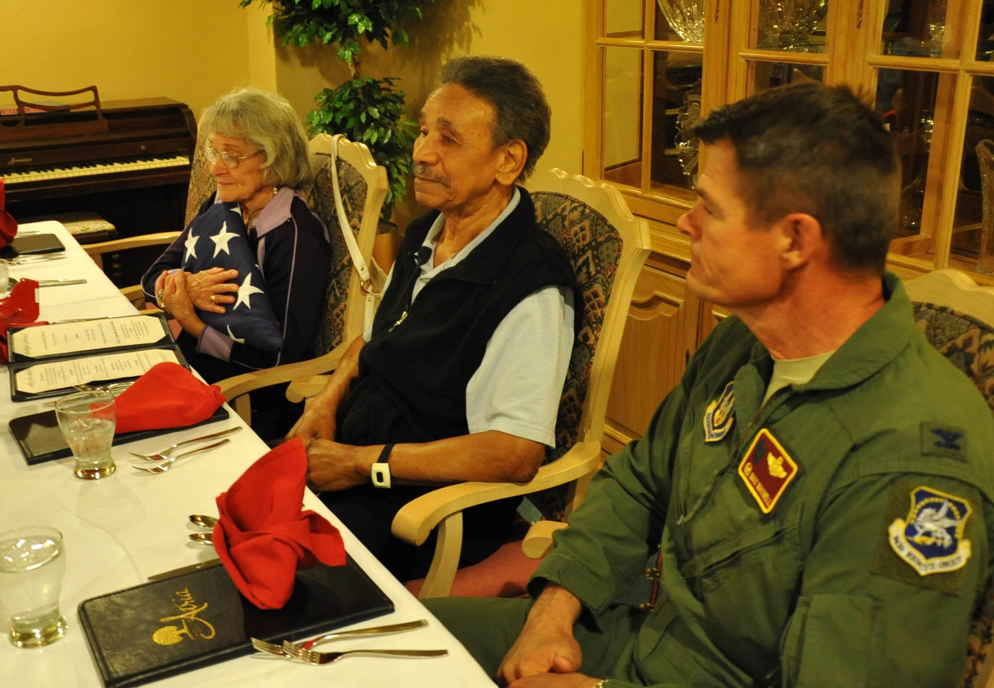 Col. Harold Maxwell, 943rd Rescue Group commander, Mr. Ralph Stewart and his wife Rosalyn sit together after Mr. Stewart was presented with an American Flag for his service during World War II. Mr. Stewart was a mechanic on the B-25 and B-26 bombers as a Tuskegee Airman. (U.S. Air Force Photo/ Master Sgt. Luke Johnson)