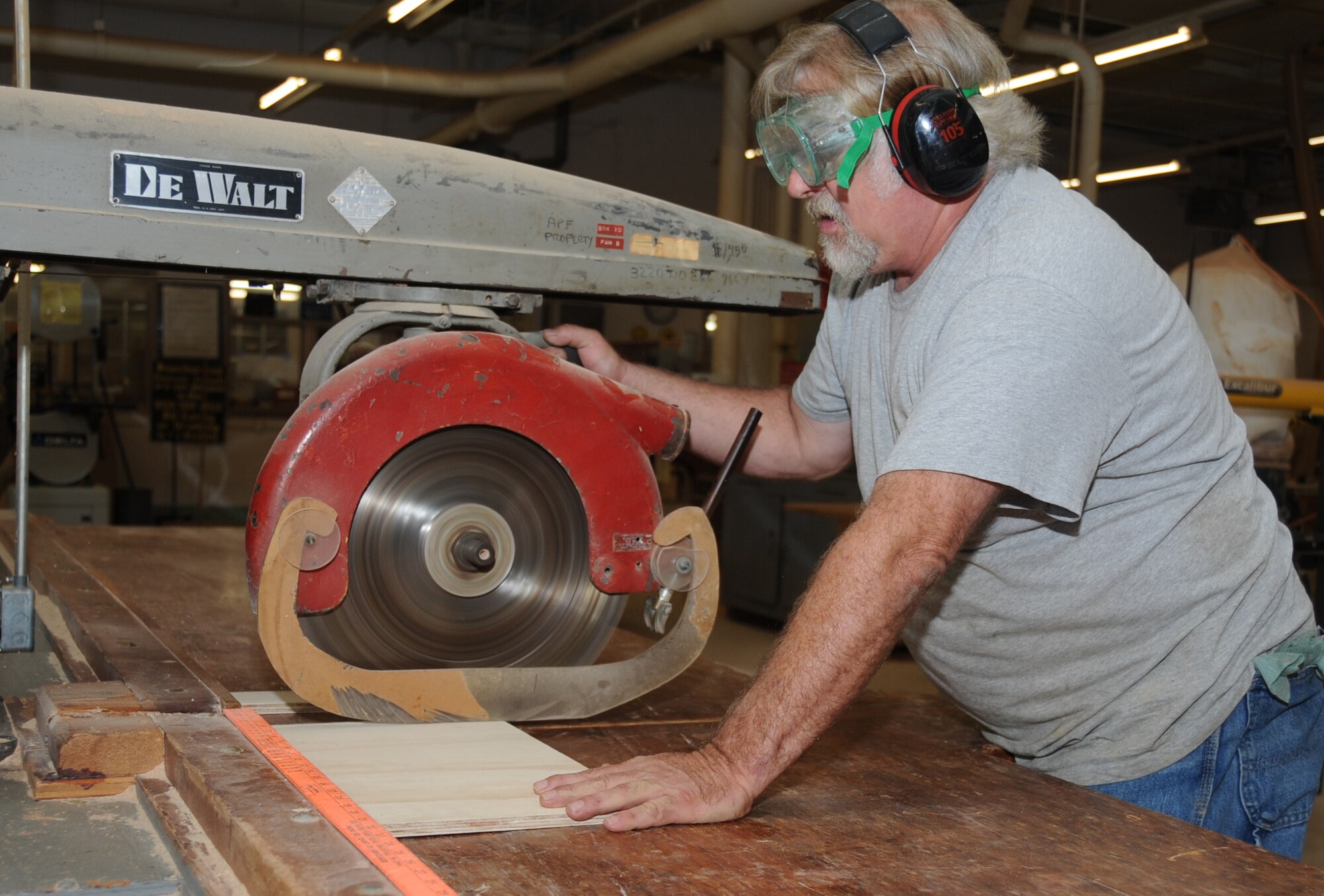 Charley Koch, 81st Force Support Squadron wood shop manager, operates a radial arm saw to cut a piece of wood for a self-help project in the wood hobby shop March 23, 2012, at Keesler Air Force Base, Miss.  Koch assists in customer self-help projects and also makes building kits for children programs at the Keesler Skill Development Center.  (U.S. Air Force photo by Kemberly Groue)