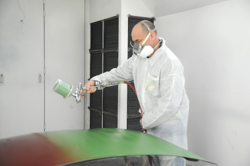 Chief Master Sgt. Tony Tingley, 89th Airlift Support Group superintendent, practices his spraying method before applying another coat of green to a hood at an auto body class at the Andrews Auto Hobby Center on March 25.  In order to achieve the best results, the paint gun must be held at the proper distance away from the substrate, moved at the correct speed with the perfect amount of air pressure and paint product coming out of the tip.  (U.S. Air Force photo/Senior Airman Torey Griffith)(released)