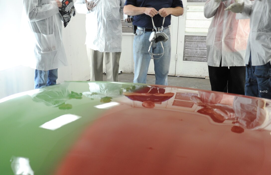 Team Andrews members revel in their reflections cast in the smooth finish of the hood they repaired and painted in an auto body class at the Andrews Auto Hobby Center on March 25.  Maaco of Waldorf donated tools, time and materials to teach the class, which was an introduction to body repair and refinishing.  (U.S. Air Force photo/Senior Airman Torey Griffith)(released) 