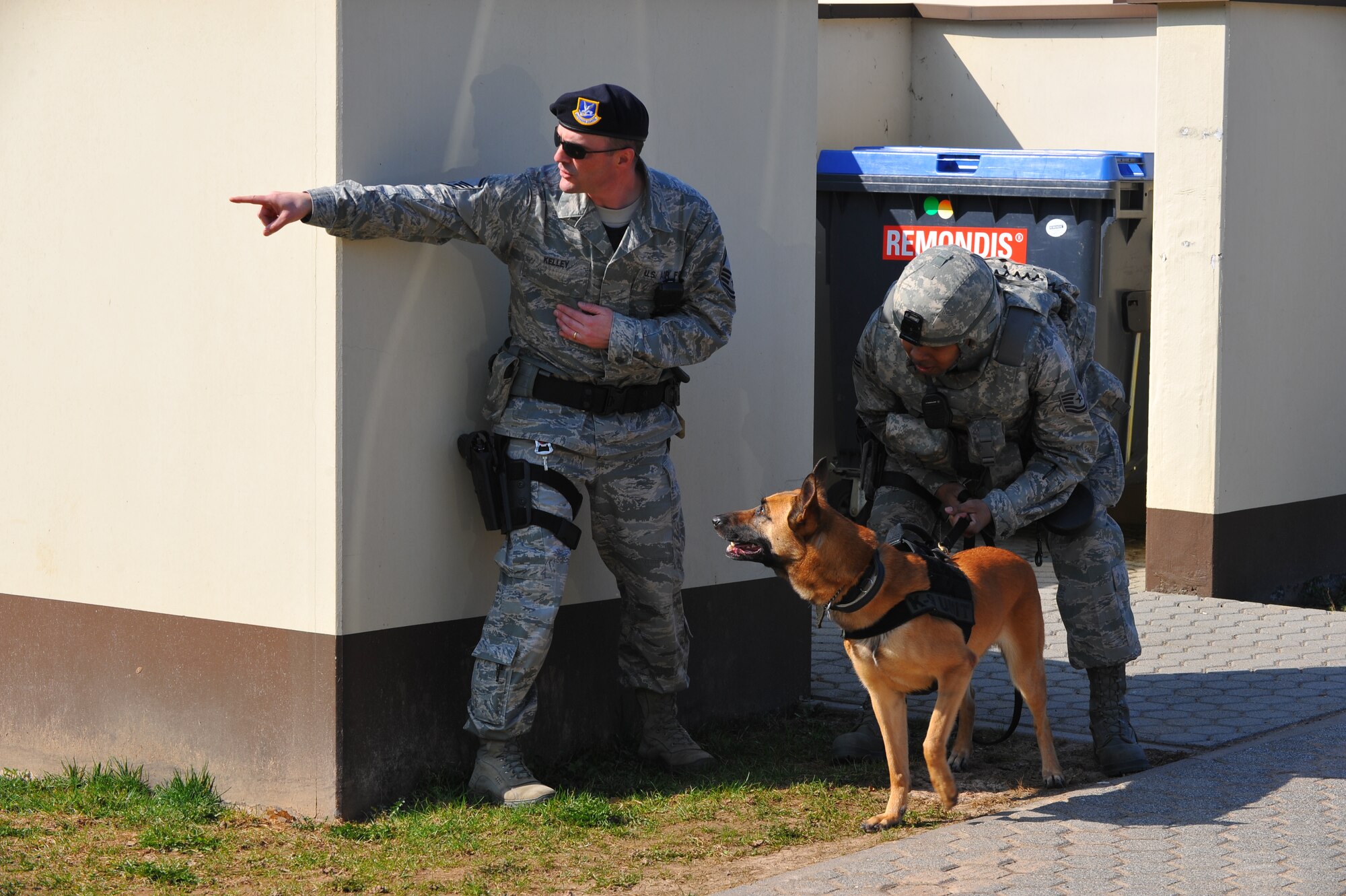 SPANGDAHLEM AIR BASE, Germany – Master Sgt. Blair Kelley, 52nd Security Forces Squadron flight chief, points out the position of a suspect to Tech. Sgt. Michael Thomas, 52nd SFS military working dog handler, during an anti-robbery exercise outside the veterinarian clinic here March 23. The exercise tested the emergency response skills of security forces members and military working dogs by ensuring Airmen are prepared to protect people and resources during real-world situations. (U.S. Air Force photo by Airman 1st Class Dillon Davis/Released)