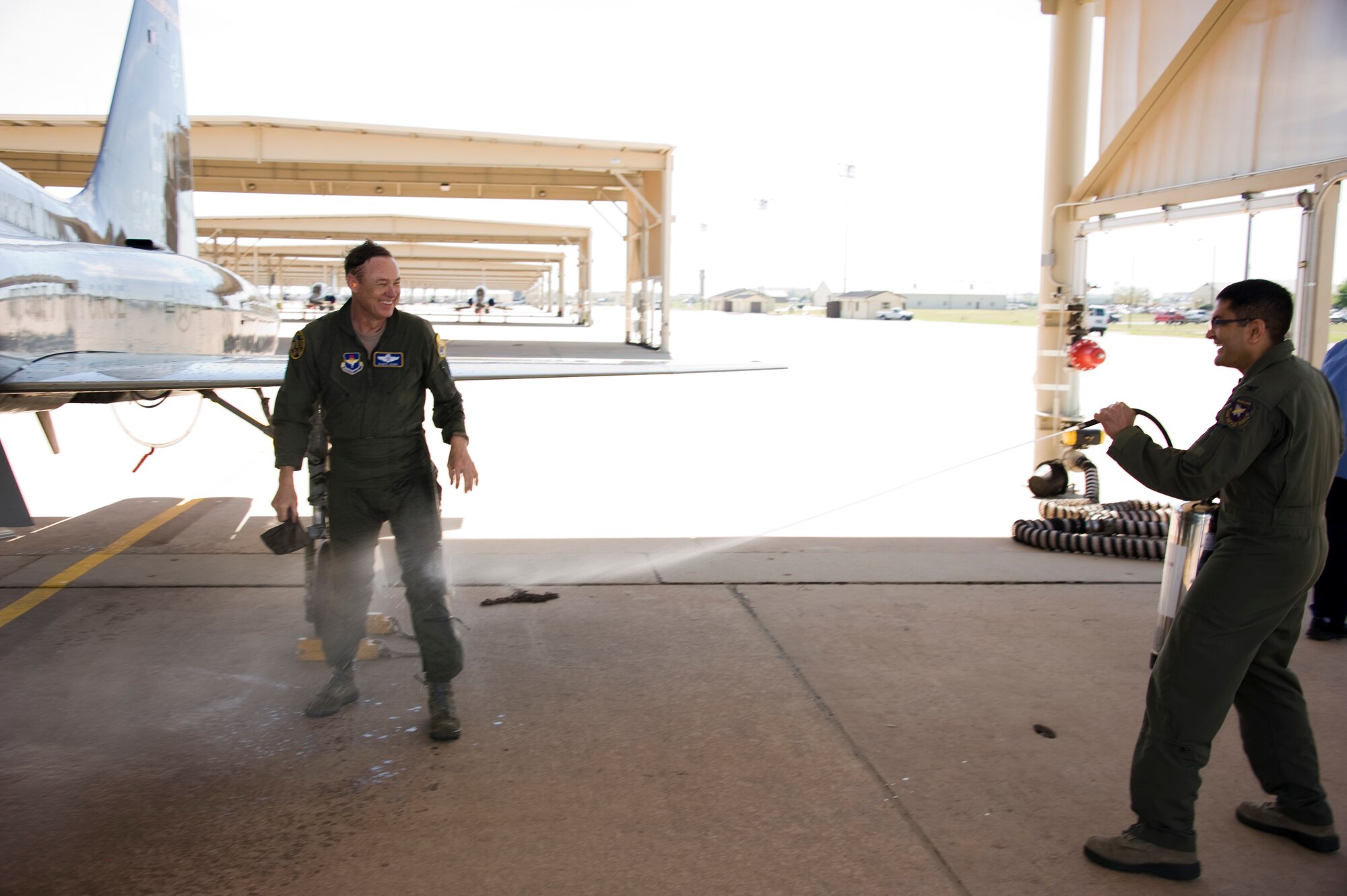 Col. Om Prakash, 82nd Training Wing vice-commander hoses down Brig. Gen. Darryl Burke, 82nd TRW commander, with water after his T-38 "fini-flight" on Mar. 26, 2012 at Sheppard Air Force Base, Texas.  Fini-flights are a long-standing military aviator tradition honoring a pilot or commander on their departure from an assignment. (U.S. Air Force photo/Danny Webb)